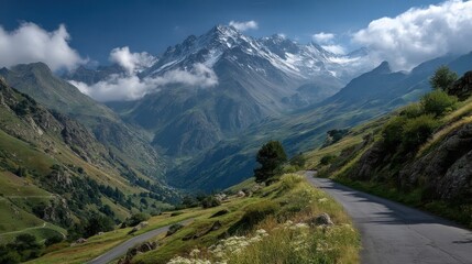 Naklejka premium Majestic snow-capped mountains dominate the landscape with low-hanging clouds and blue sky patches.