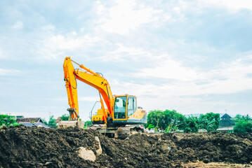 Obraz premium Excavator on limestone mountain. Backhoe digging sand, soil on limestone mountain, Heavy construction equipment is digging at construction site. Excavator is working on soil, foundation. Road construc