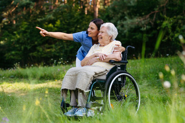 Home nurse taking care of elderly woman in wheelchair.