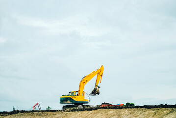 Excavator on limestone mountain. Backhoe digging sand, soil on limestone mountain, Heavy construction equipment is digging at construction site. Excavator is working on soil, foundation. Road construc