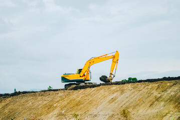Excavator on limestone mountain. Backhoe digging sand, soil on limestone mountain, Heavy construction equipment is digging at construction site. Excavator is working on soil, foundation. Road construc