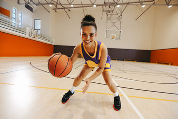 Young basketball player practicing dribbling on an indoor court