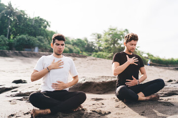 Two men seated in deep breath awareness, hands on chest and belly—anchoring presence as method...
