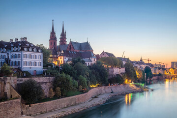 Basel, Switzerland - View of the left bank of Rhine river with old town and Baseler Munster cathedral at dusk