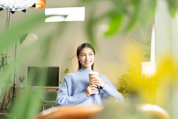 Young Asian woman enjoying a peaceful moment reading a book near window. Calm lifestyle, self-learning, and mindfulness at home.