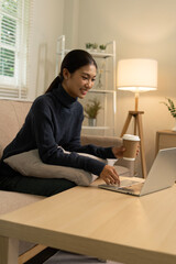 Young Asian woman enjoying a peaceful moment reading a book near window. Calm lifestyle, self-learning, and mindfulness at home.