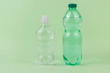 Clear and green bottles with a green apple on light green surface symbolizing hydration balance and daily self care routine