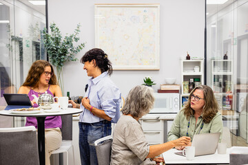 Multigenerational women colleagues collaborating in coworking office space
