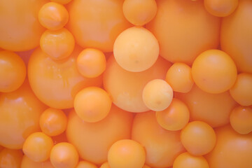 Orange balloons of various sizes forming a festive background. Decorative element for party, celebration, birthday, or abstract design concept.