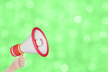 Womans hand holding  megaphone on blurred green summer festive background
