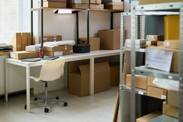 Empty office workspace showing organized shelves with cardboard boxes, packages, folders and...