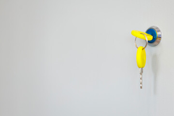 Yellow key in lock on modern door close-up. Real estate or rental idea symbolized by key in lock.