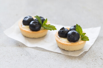 Two Mini round Blueberry tartlets. Light background. Close up