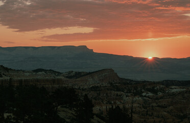 Naklejka premium Breathtaking sunset over majestic mountains and rugged landscape at dusk