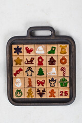 Advent Calendar. 25 Christmas cookies. On a wooden plate. White background. Top view	