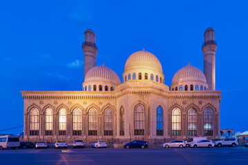 Bibi-Heybat Mosque at night in Baku, Azerbaijan. Illuminated Islamic architecture featuring domes and minarets under a deep blue sky