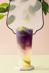 Refreshing lime mojito with white to purple gradient and lime slice