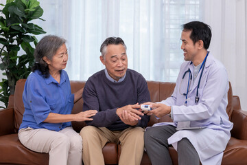Obraz premium health care worker in uniform with stethoscope,holding tablet computer,taking pulse oximeter measurement and giving advice elderly couple at home,home health services,home care