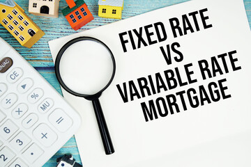Notepad with "Notepad with "Fixed Rate Vs Variable Rate Mortgage" with Calculator, magnifying glass and house model on wooden background