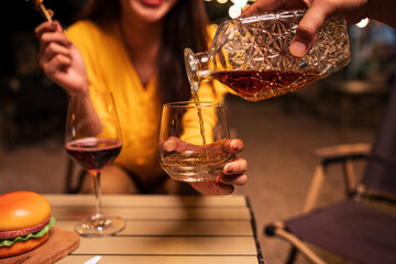 Pour whiskey into a glass.

