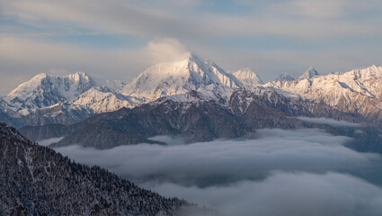 Fototapeta premium Majestic Snowy Mountain Range Landscape with Foggy Valley Scenery in Winter