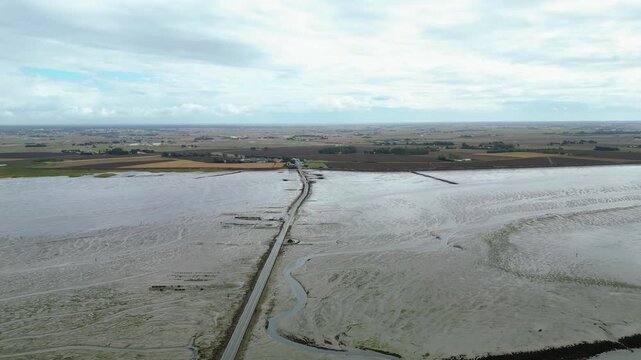 Aerial view of oyster farms at low tide near the Passage du Gois, Noirmoutier Island, France. Long rows of oyster beds and water channels create a unique landscape, showcasing traditional oyster
