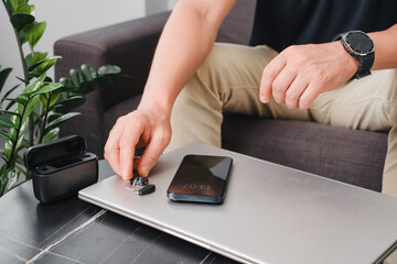 Modern digital hearing aids, smartphone and charging case on a sleek office table, with person...