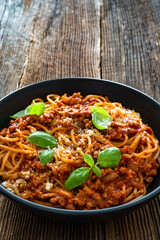 Spaghetti con ragù alla bolognese - pasta with minced meat and tomato sauce on wooden table