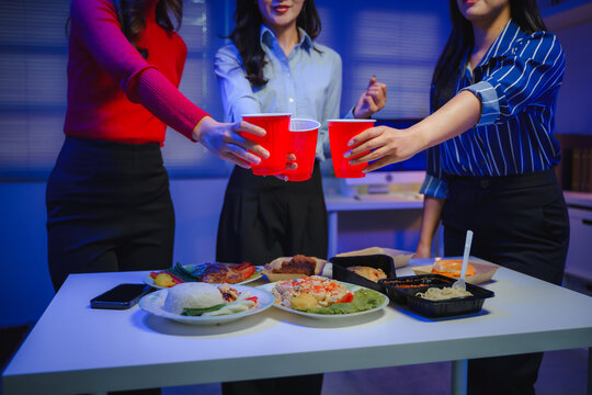 Women colleagues celebrating success and friendship with a toast during an after-hours office party