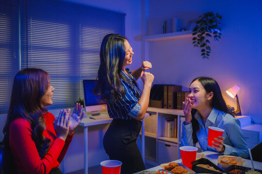 Asian young women having office party, dancing and celebrating with friends, coworkers enjoying after work fun