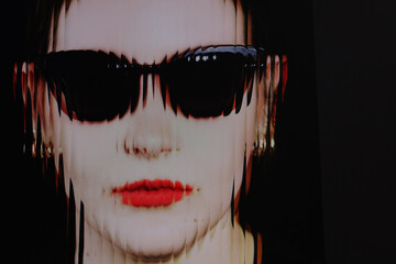 Closeup face of a woman with red lipstick and sunglasses with ripple glass effect
