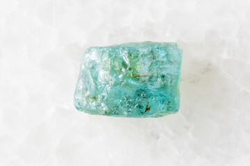rough starlite blue zircon mineral on white marble