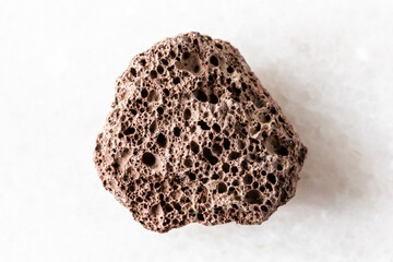 sample of rough brown pumice mineral on white