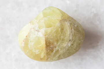 sample of tumbled saamite mineral on white marble