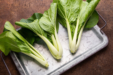 raw Pak choi or Bok Choy vegetable on brown background, fresh asian cabbage