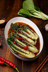 fried pak choi cabbage with garlic and soy sauce, Pak Choi or Bok Choy on wooden background