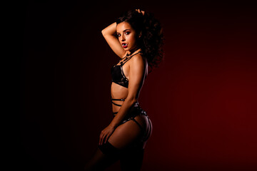 Glamorous model portrays a seductive vampire character, embodying Halloween's allure with a bold...