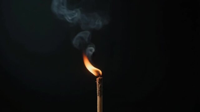 Cinematic of burning incense sticks with smoke over a black