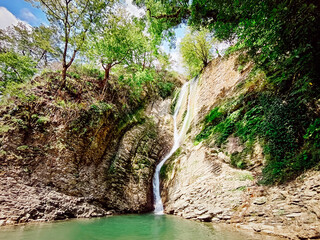 Mountain waterfall, beautiful landscape. Water falls from the mountains into the river.