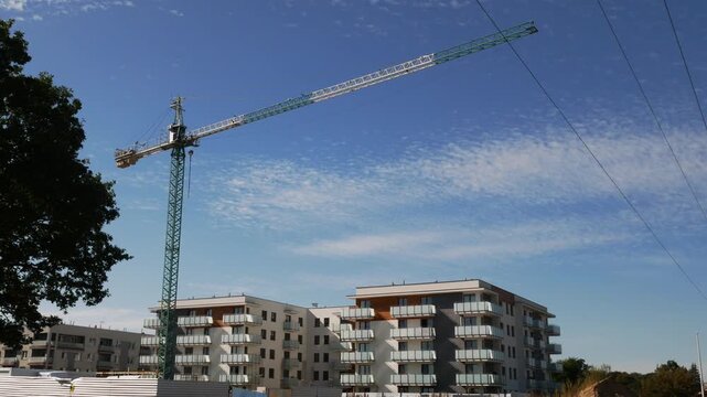 Modern residential complex with crane and ongoing construction, urban cityscape, new home development, real estate footage