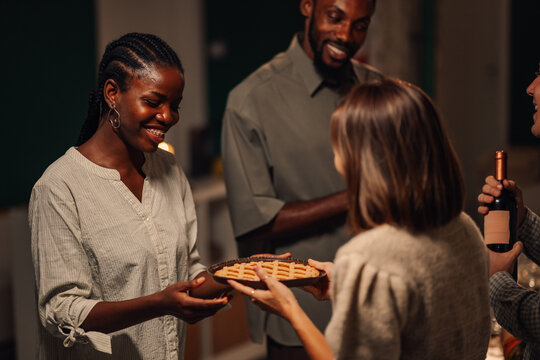 Friends sharing pie and wine at thanksgiving celebration