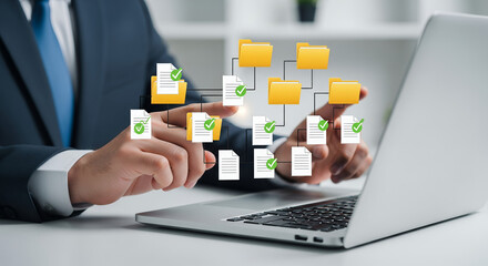 Business professional working on a laptop, with document icons floating above