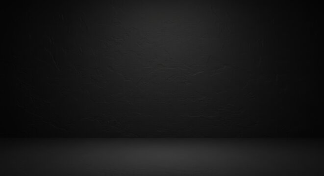 A dark, empty studio space with a textured black background and floor.