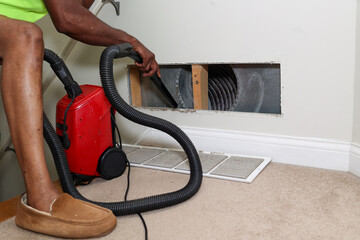 a portrait of a black man cleaning a air duct
