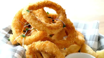 Delicious crispy fried calamari rings served on a checkered napkin isolated on white background