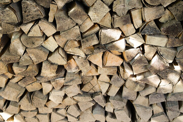 Stack of firewood logs neatly piled outdoors. Natural texture of chopped wood, rustic background, renewable energy source, eco-friendly fuel for fireplace, stove, or campfire. High quality photo