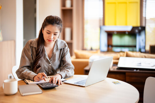 Deduction planning, debt asian young woman  hand using calculator to calculating  money balance from bill and income, cost budget expenses for pay money form personal individual on table at home.