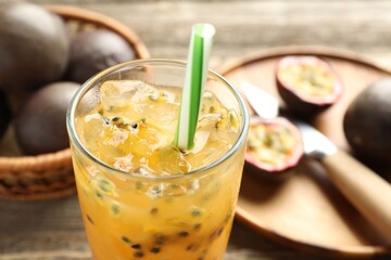 Tasty passion fruit drink and fresh fruits on wooden table, closeup