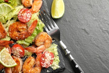 Tasty grilled shrimps with salad served on black table, closeup with space for text. Delicious seafood dish