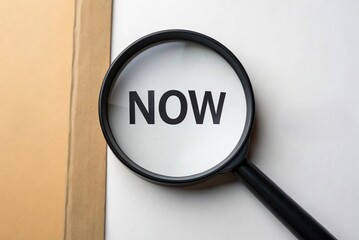 Magnifying glass over the word now, isolated on white background